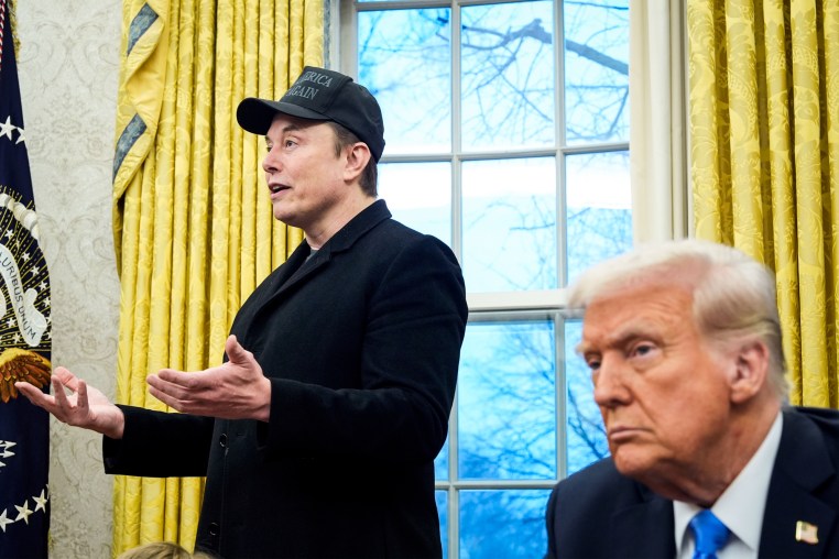 Donald Trump listens as Elon musk speaks