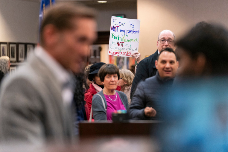 ROSWELL, GA - FEBRUARY 20- An attendee holds up a sign referenc