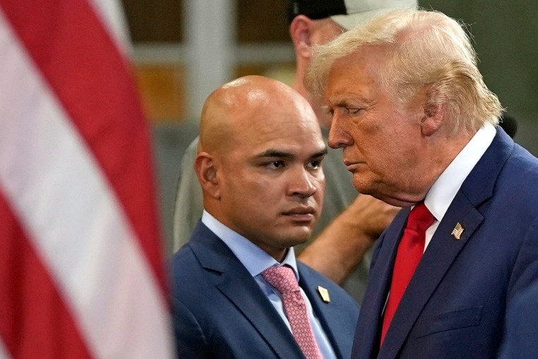 Donald Trump walks past aide Walt Nauta at a campaign event 