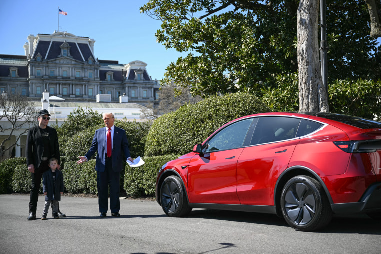 Image: President Donald Trump, alongside Tesla CEO Elon Musk, speaks next to a Tesla vehicle on the South Portico of the White House