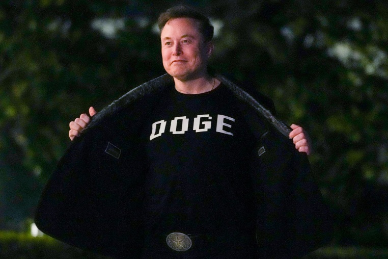 Elon Musk with a shirt that says "DOGE"
