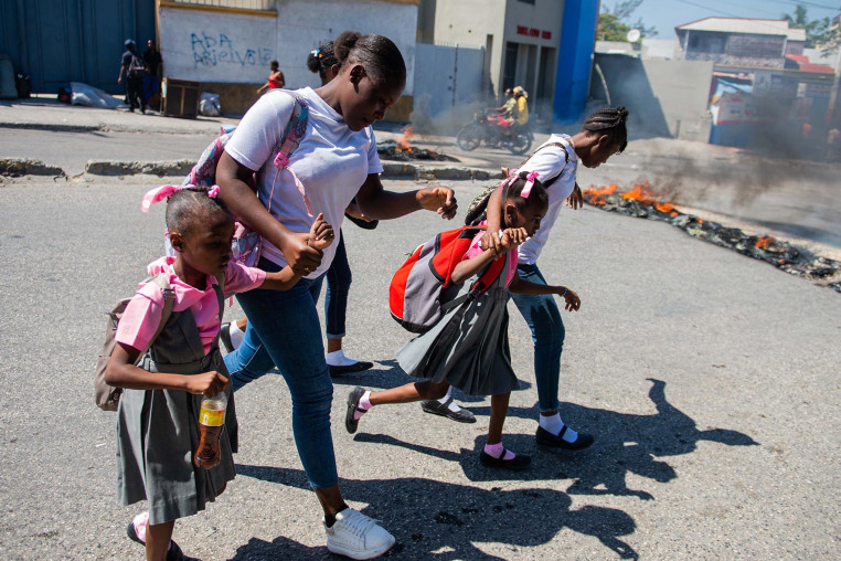 People flee gang violence during an anti-government demonstration in of Port-au-Prince, Haiti, on Feb. 20, 2025.