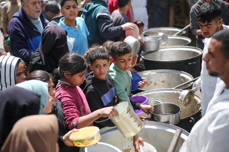 Palestinian kids collect food.