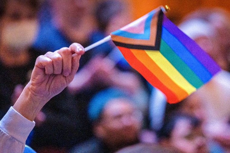 A person waves a pride flag