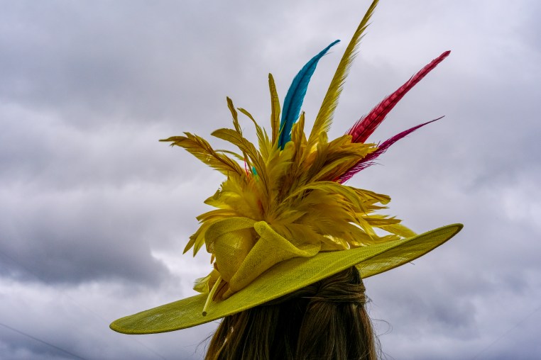 A person wears a hat as storm clouds hang overhead.