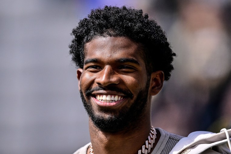  Shedeur Sanders smiling during a ceremony to retire his jersey 