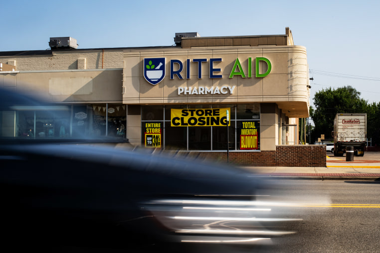 A car passes by Rite Aid store with a "Store Closing" sign.