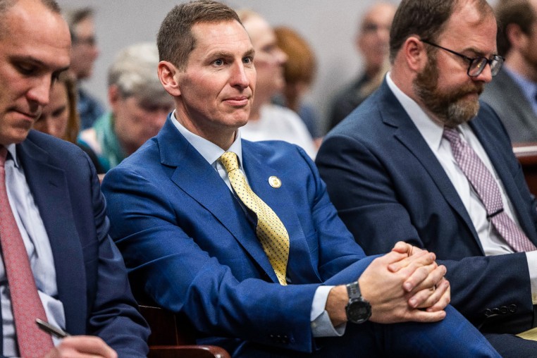 Jefferson Griffin sits between two people