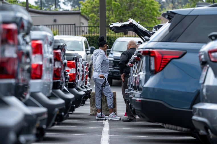 Customers look at cars at a dealership
