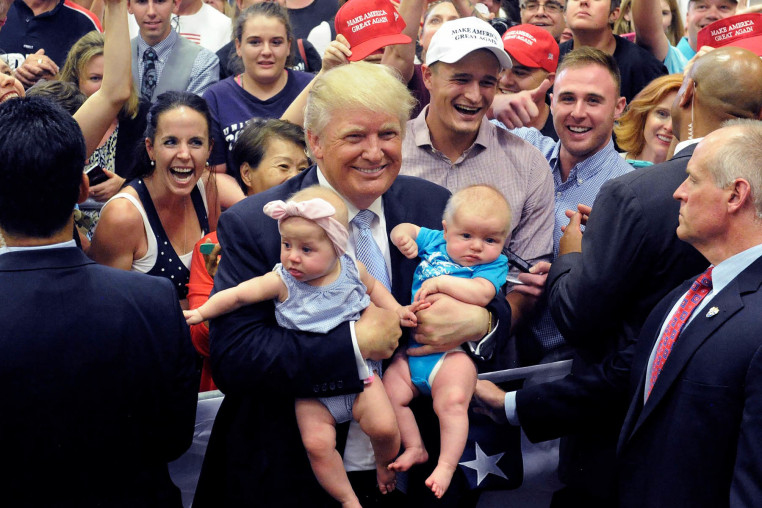 Donald Trump holding two babies.