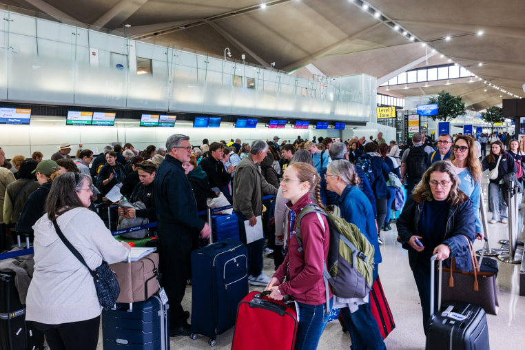  People wait in line for a delayed flight at Newark International Airport