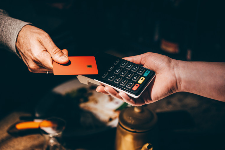 Man pays with a card in a cafe.