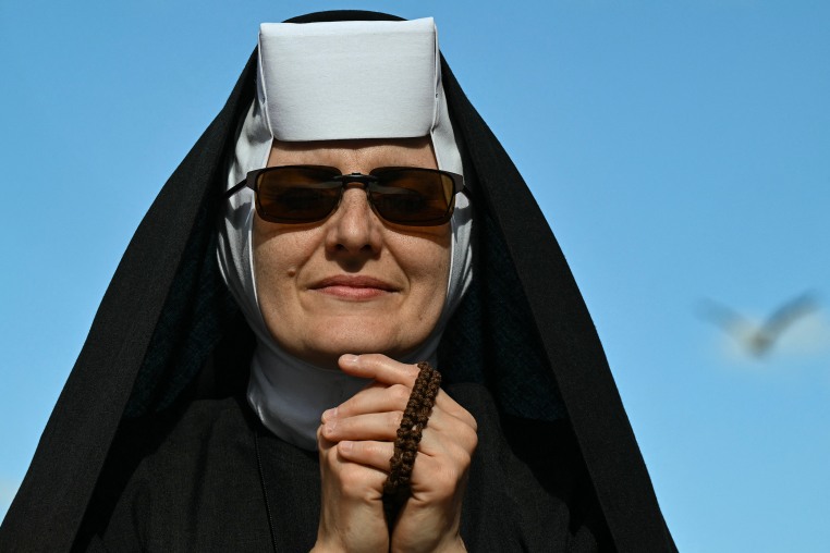 A nun prays on St Peter's Square ahead of the conclave