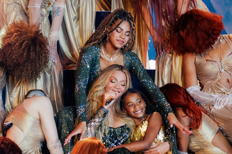 Beyonce on stage with Rumi and Blue Ivy, dancers surround them