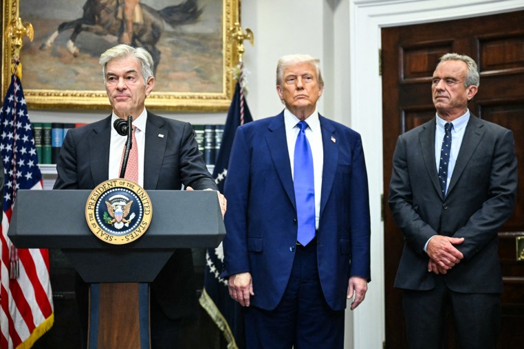 Mehmet Oz, left, speaks at the podium while President Donald Trump, and Robert F. Kennedy Jr. watch on the side