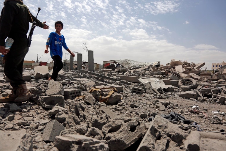 A security guard asks a child to stop walking over the rubble of a building destroyed by U.S. strikes on April 27, 2025 in Sana'a, Yemen. 
