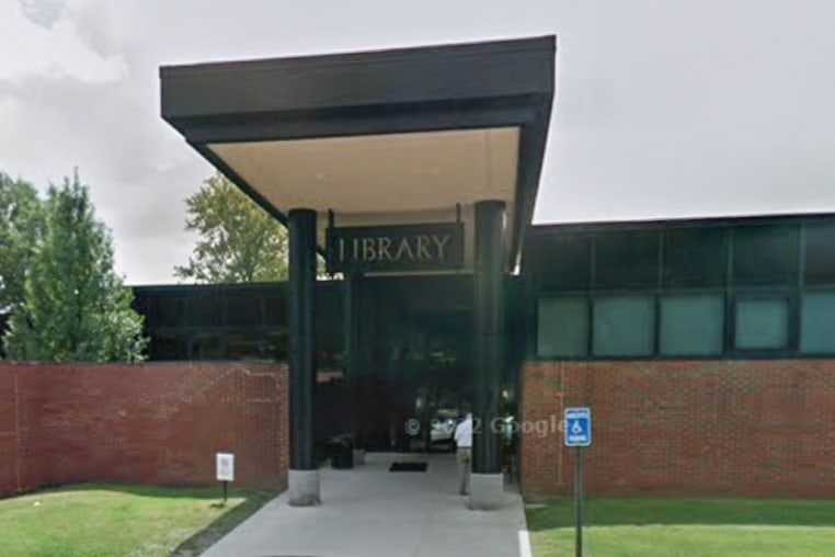 A library building is seen from the exterior from the parking lot