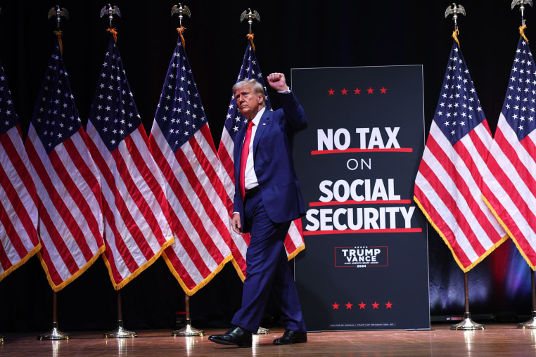 Donald Trump holds his fist up on stage