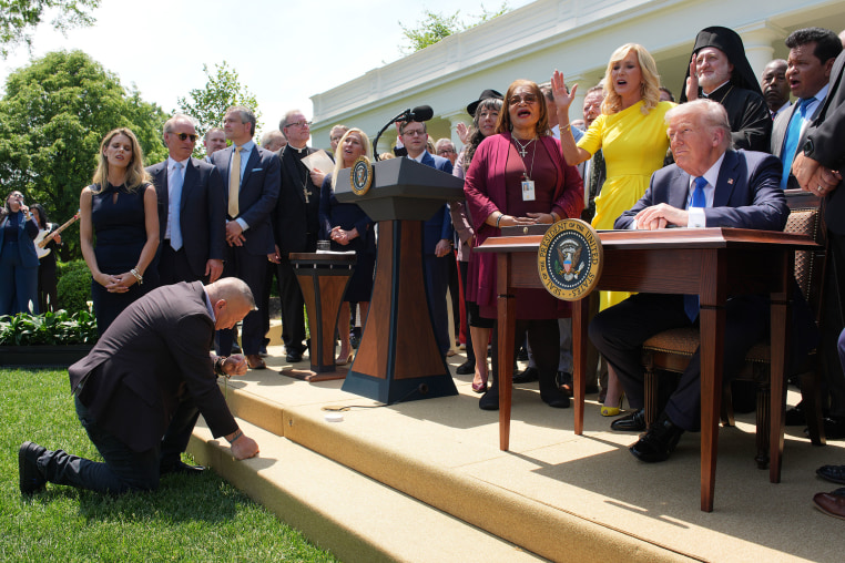 President Donald Trump, joined by lawmakers and religious leaders, prepares to sign an executive order establishing the Commission on Religious Liberty during a National Day of Prayer event in the Rose Garden at the White House on May 1, 2025.