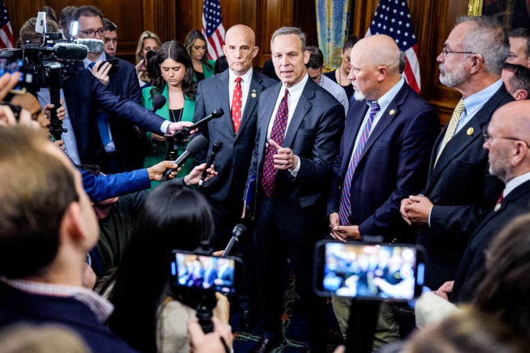 Clay Higgins, Andy Harris, Chip Roy, Scott Perry, and Keith Self in the center of a crowd of interviewers