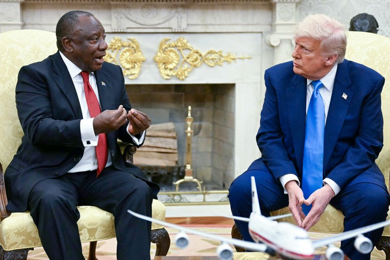Cyril Ramaphosa gestures while he speaks with Donald Trump.