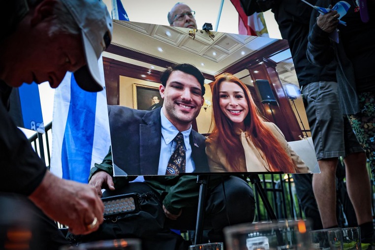 A photo of Yaron Lischinsky and Sarah Milgrim is displayed at a vigil outside the White House on May 22, 2025.