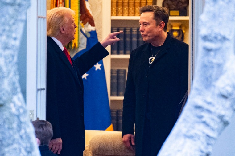 Donald Trump, left, points a finger at Elon Musk inside of an office while standing