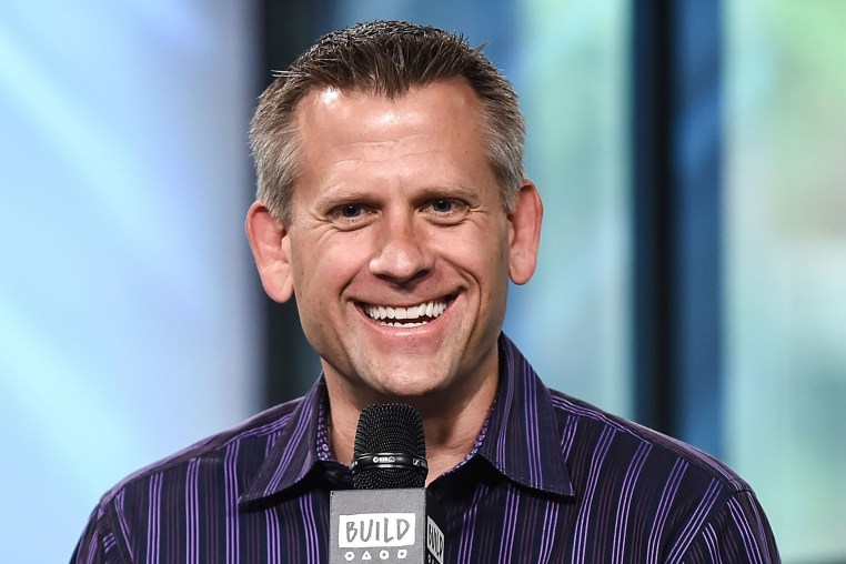 John Brenkus smiles while he speaks.