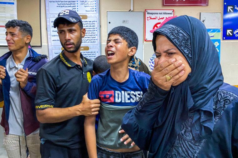 Palestinians react as they await news of a relative who was injured in Israeli strikes.