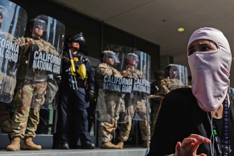 A protester stands in front of National Guardsmen outside of the Robert Young Federal Building on June 9, 2025 in downtown Los Angeles.