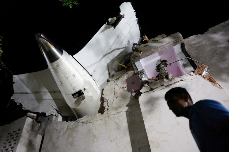 A person walks past debris at the crash site after an Air India aircraft crashed during take-off from an airport in Ahmedabad, India, on June 12, 2025. 