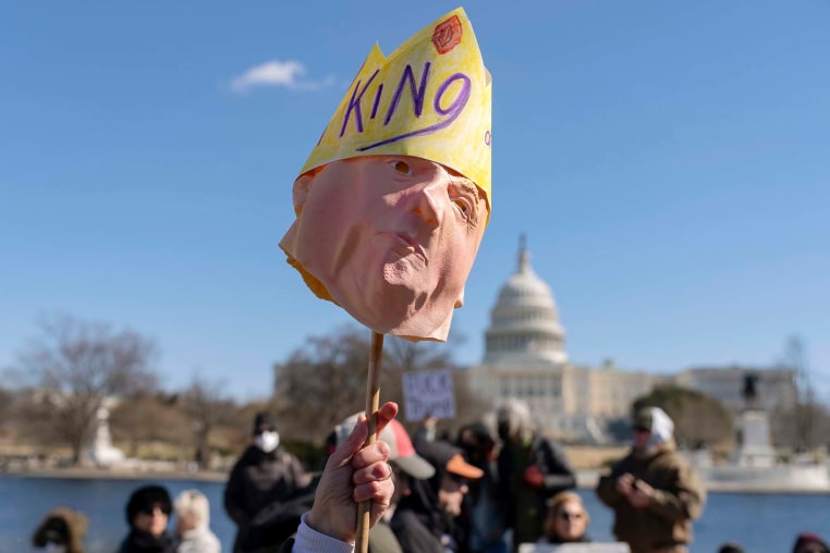A protester holds up a Trump mask at the Presidents Day "No Kings" protest on Feb. 17, 2025, in Washington.