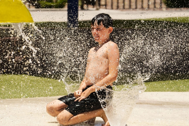 A boy plays at a splash pad at Anthem Community Park