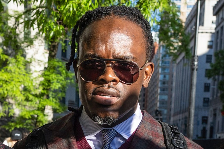 Tyrone Blackburn walks outside, wearing sunglasses
