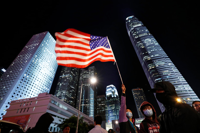A protestor holds high a U.S. flag in Hong Kong, Thursday, Nov. 28, 2019. 