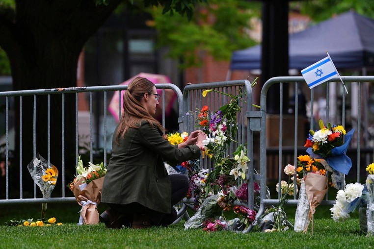 A woman places flowers at a makeshift memorial for victims of an attack outside of the Boulder County Courthouse Tuesday, June 3, 2025, in Boulder, Colo. 