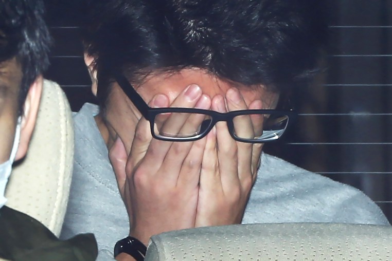 Takahiro Shiraishi covers his face with his hands