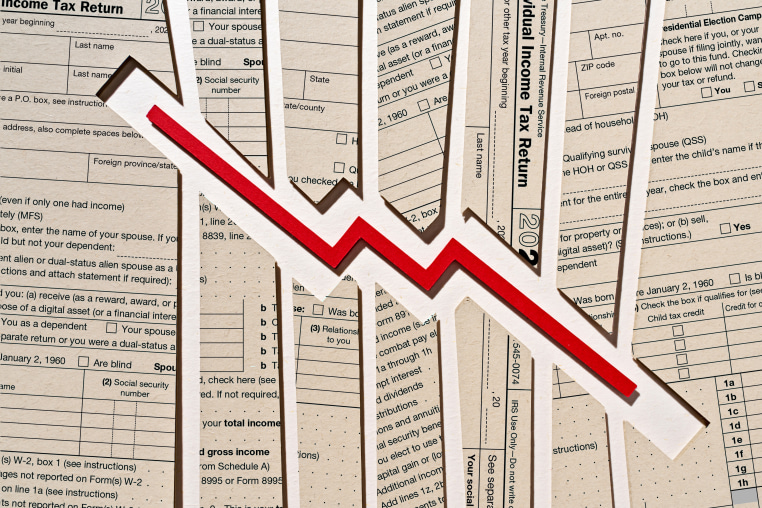 Photo Illustration: a downward trending arrow set against tax return forms