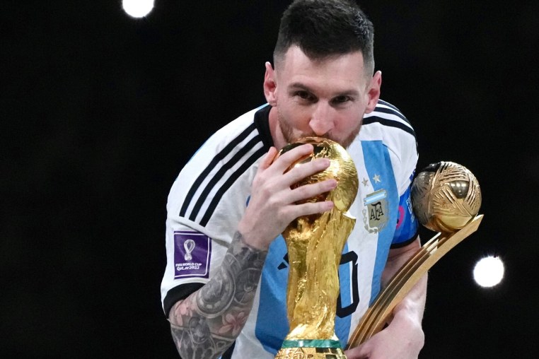 LUSAIL CITY, QATAR - DECEMBER 18: Adidas Golden Ball winner Lionel Messi of Argentina kisses the FIFA World Cup Winner's Trophy at the award ceremony following the FIFA World Cup Qatar 2022 Final match between Argentina and France at Lusail Stadium on December 18, 2022 in Lusail City, Qatar. (Photo by Cui Nan/China News Service/VCG via Getty Images)