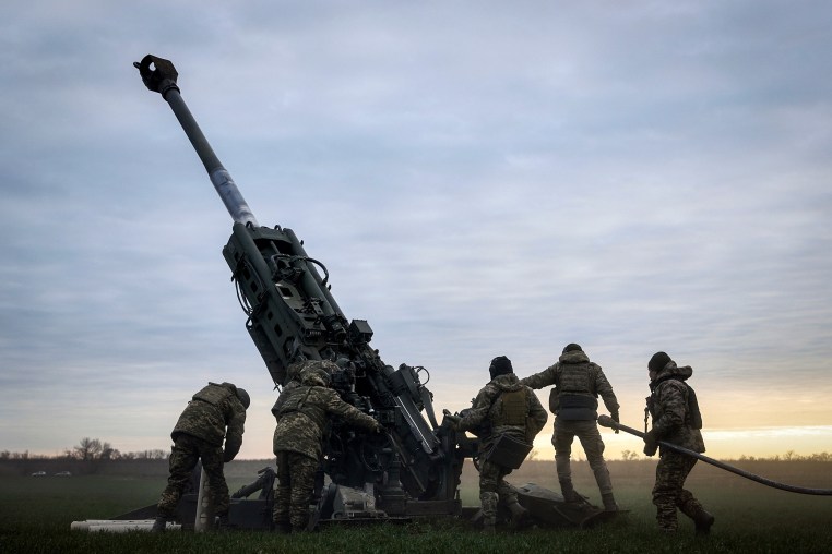 Ukrainian soldiers prepare a U.S.-supplied M777 howitzer to fire 