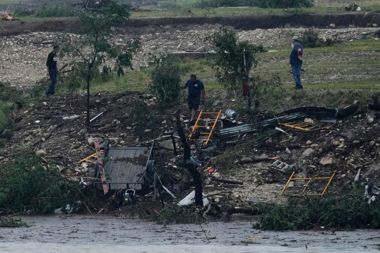 Men survey damage left by a raging Guadalupe River