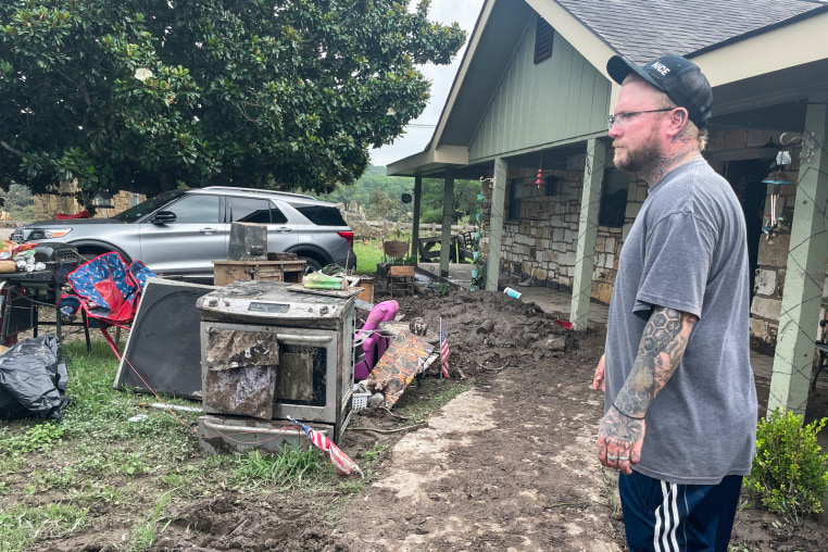 Matt Meagher stands in his flood damaged backyard