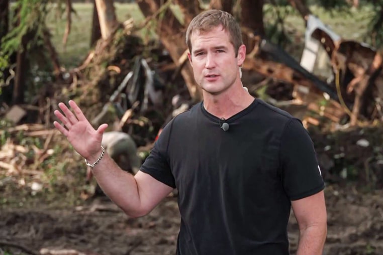 Morgan Chesky speaks outside in the forest near flood debris
