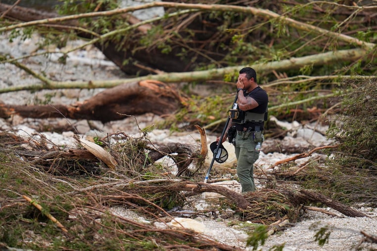 A Sheriff's deputy pauses while combing through the banks of the Guadalupe River near Camp Mystic, Saturday, July 5, 2025, in Hunt, Texas.