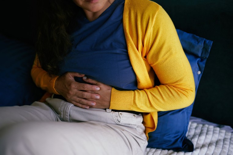 Person Experiencing Abdominal Discomfort While Resting at Home