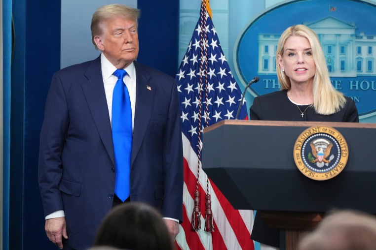 Attorney General Pam Bondi speaks to reporters as President Donald Trump listens.