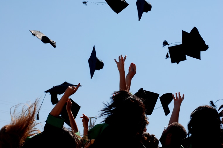 graduates throwing their caps in the sky