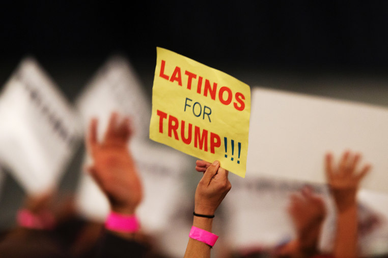 A supporter holds a sign that reads " Latinos for Trump"