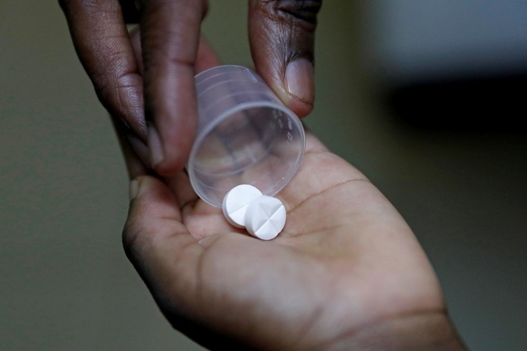 A nurse dispenses an anti-retroviral drug to a child in Kenya
