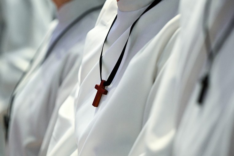 Acolytes wear wooden crosses around their necks